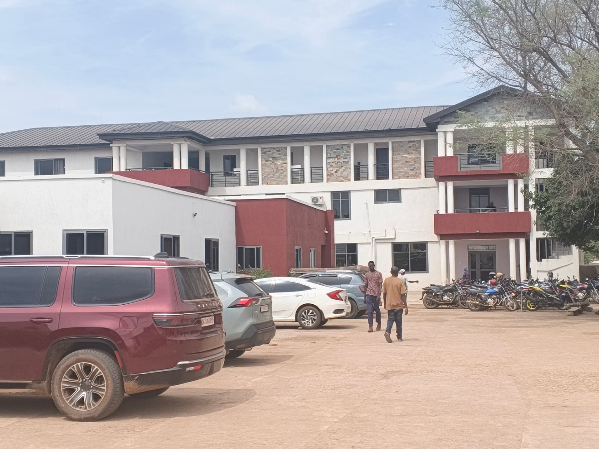The two-storey ward and physiotherapy block at Ultima Platz Hospital, with white walls, maroon panels and stone cladding.
